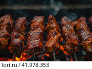 Gaucho cooking the meat on the fire, making the barbecue on the coals, Photos and menus of cafes and restaurants, Magazines. Стоковое AI-изображение, AI-художник Ирина Ручушкина / Фотобанк Лори
