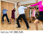 Man practicing jitterbug with female partner in dance studio. Стоковое фото, фотограф Яков Филимонов / Фотобанк Лори