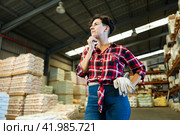 Thoughtful female storekeeper looking for tedious goods in building materials warehouse indoor. Стоковое фото, фотограф Яков Филимонов / Фотобанк Лори