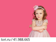Serious funny little girl in pink dress arms crossed at pink backdrop, posing serious looking. Lovely kid lady coquette expressing emotion, studio shot. Child image emotion concept. Copy ad text space. Стоковое фото, фотограф Aleksandr Golubev / Фотобанк Лори