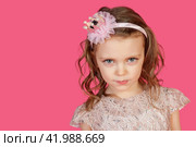 Portrait of serious little girl posing at pink background, sternly looking at camera. Cute emotional kid lady with blue eyes in pink dress, studio shot. Child image emotion concept. Copy ad text space. Стоковое фото, фотограф Aleksandr Golubev / Фотобанк Лори