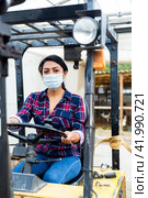 Masked hispanic woman sits behind the wheel of a tractor autocar during a pandemic. Стоковое фото, фотограф Яков Филимонов / Фотобанк Лори