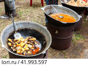 Cooking appetizing traditional fast food in a large cauldrons outdoors. Стоковое фото, фотограф FotograFF / Фотобанк Лори