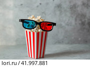 A banner for the film industry. The release date of the film. 3D glasses and popcorn in striped cups on a stylish concrete-gray background. The premiere of the film. (2024 год). Стоковое фото, фотограф Photojuli / Фотобанк Лори