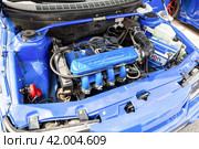 Engine under the hood of a tuning Lada 2110 vehicle with a variety of devices and improvements (2023 год). Редакционное фото, фотограф FotograFF / Фотобанк Лори