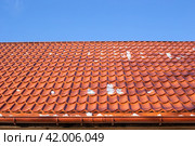 Roof made of metal tiles on a winter sunny day with remnants of snow. Roof cleaning. Стоковое фото, фотограф Коханова Наталья / Фотобанк Лори