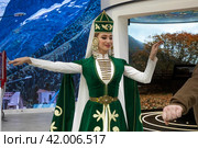 Мужчина и девушка в традиционных национальных костюмах танцуют кавказский танец у стенда Карачаево-Черкесской Республики на выставке-форуме "Россия" на ВДНХ в городе Москве, Россия (2024 год). Редакционное фото, фотограф Николай Винокуров / Фотобанк Лори