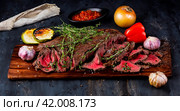 кусок аппетитного жареного мяса с овощами на доске. Стоковое AI-изображение, AI-художник Данил Хусаинов / Фотобанк Лори