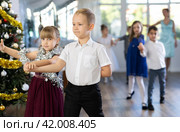 Tween boy and girl performing waltz during Christmas event at school. Стоковое фото, фотограф Яков Филимонов / Фотобанк Лори