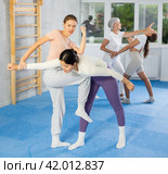 Woman practicing wristlock with elbow and knee blows at self-defense training. Стоковое фото, фотограф Яков Филимонов / Фотобанк Лори