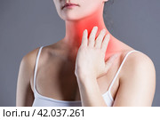 Sore throat, woman with pain in neck, gray background. Стоковое фото, фотограф Станислав Тарко / Фотобанк Лори