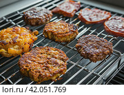 grilled lamb and lamb patties on a grill rack. Стоковое AI-изображение, AI-художник Юлия Гапеенко / Фотобанк Лори