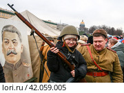 Ребенок с винтовкой и мужчина в советской военной форме на мероприятие в честь 80-летия полного освобождения Ленинграда от фашистской блокады на Дворцовой площади (2024 год). Редакционное фото, фотограф Евгений Кашпирев / Фотобанк Лори