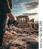A photographer takes pictures of ancient ruins. The concept of historical tourism. The view from the back. Generated by And. Стоковое AI-изображение, AI-художник Ярославский Максим / Фотобанк Лори