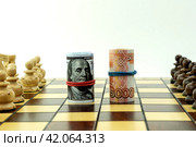 dollars and rubles on the chessboard, the concept of confrontation (2020 год). Редакционное фото, фотограф Igor Skripachev / Фотобанк Лори