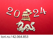 Новый год 2024. Цифры года на красном фоне. Дракон китайский. Редакционное фото, фотограф Елена Бобкова / Фотобанк Лори