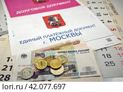 Единый платёжный документ (ЕПД) за жилищно-коммунальные услуги, долговой документ за неуплату ЖКУ, деньги лежат на листках календаря. Плати вовремя. Стоковое фото, фотограф Владимир Устенко / Фотобанк Лори