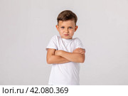Negative human emotions, reactions and feelings. Isolated shot of moody displeased angry little boy crossing arms on his chest, pouting lips, having offended facial expression, being capricious. Стоковое фото, фотограф Ирина Михайличенко / Фотобанк Лори