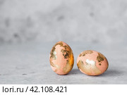 Stylish Peach Fuzz Easter eggs with a coating of golden sweat on a gray background. The concept of happy Easter 2024. Стоковое фото, фотограф Photojuli / Фотобанк Лори