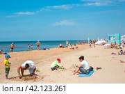 Vacationing tourists on the sandy shore of the Black Sea. Vityazevo, Russia (2023 год). Редакционное фото, фотограф Коханова Наталья / Фотобанк Лори