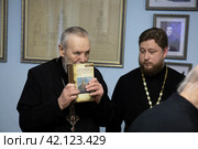 Епископ Балашихинский и Орехово-Зуевский Николай смотрит свежий тираж книги "Летопись Николо-Архангельской церкви" (2024 год). Редакционное фото, фотограф Дмитрий Неумоин / Фотобанк Лори