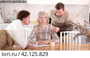 Old woman deciding and signing inheritance papers in family circle. Old woman signing papers. Стоковое видео, видеограф Яков Филимонов / Фотобанк Лори