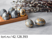 Stylish grey Easter eggs made of marble and concrete with a golden potala on a grey background. Coloring eggs with natural dye karkade tea. . The concept of a happy Easter. Стоковое фото, фотограф Photojuli / Фотобанк Лори