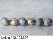 Stylish grey Easter eggs made of marble and concrete with a golden potala on a grey background. Coloring eggs with natural dye karkade tea. . The concept of a happy Easter. Стоковое фото, фотограф Photojuli / Фотобанк Лори