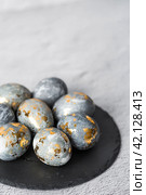Stylish grey Easter eggs made of marble and concrete with a golden potala on a grey background. Coloring eggs with natural dye karkade tea. . The concept of a happy Easter. Стоковое фото, фотограф Photojuli / Фотобанк Лори
