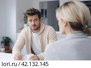 Couple conversation in kitchen over coffee, facing relationship difficulties and considering divorce, seeking solutions to reconnect and rebuild their bond. Стоковое AI-изображение, AI-художник Оксана Гильман / Фотобанк Лори