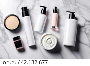 Black and white bottles for cosmetics and personal skin care products flat lay top view. Empty label template mock up. Blank packaging on marble white background. Containers set, cream, lotion, powder. Стоковое AI-изображение, AI-художник Марина Демидюк / Фотобанк Лори