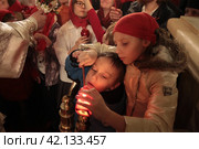 Пасха 2018 года в Успенском храме Новодевичьего монастыря, Москва. Митрополит Ювеналий раздаёт благодатный огонь. Редакционное фото, фотограф Дмитрий Неумоин / Фотобанк Лори