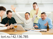Happy male friends exulting after successful virtual investment. Стоковое фото, фотограф Яков Филимонов / Фотобанк Лори