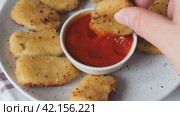 Chicken fried nuggets are dipped in tomato ketchup sauce. Concept of unhealthy fast food nutrition. Стоковое видео, видеограф Глущенко Елена / Фотобанк Лори