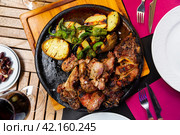Pieces of roasted veal chop with baked potatoes and jalapenos. Стоковое фото, фотограф Яков Филимонов / Фотобанк Лори