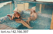 Girls in winter relax in a warm pool after sauna, enjoying coolness and relaxation. Стоковое видео, видеограф Юрий Поздников / Фотобанк Лори