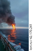 Fire on an offshore oil tanker. Стоковое AI-изображение, AI-художник Кирилл Черезов / Фотобанк Лори