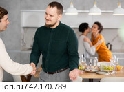 In home, male friends shake hands, say goodbye after socializing and gatherings. Стоковое фото, фотограф Яков Филимонов / Фотобанк Лори