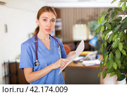 Nurse standing in hall with clipboard in hands. Стоковое фото, фотограф Яков Филимонов / Фотобанк Лори
