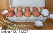 Video of chicken eggs in environmental packaging made of cardboard, egg shells and dry wheat ears on wooden table. Dietary organic healthy food. Стоковое видео, видеограф Виктория Катьянова / Фотобанк Лори