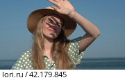 Authentic young woman in straw hat and light green polka dot dress on background of sea waves. Стоковое видео, видеограф А. А. Пирагис / Фотобанк Лори