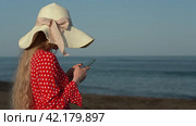 Woman using smartphone, reading and typing text messaging on beach on background of waves of sea. Стоковое видео, видеограф А. А. Пирагис / Фотобанк Лори