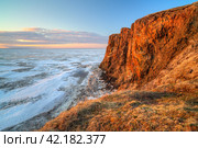 Picturesque arctic landscape. View from the coast to the cape and the frozen sea covered with ice. Beautiful rocks and cliff at sunrise. June in the Arctic. Cape Dionysius, Chukotka, Far East Russia. Стоковое фото, фотограф Андрей Степанов / Фотобанк Лори