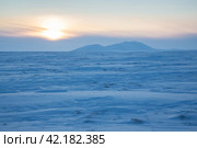 Winter arctic landscape. View of the snow-covered tundra and snow-capped mountains. Cold frosty winter weather. Endless Arctic Desert. Northern nature of the polar region. Sunset. Chukotka, Russia. Стоковое фото, фотограф Андрей Степанов / Фотобанк Лори