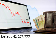 Vladimir, Russia - February 2022: Russian money in the wallet against the backdrop of declining financial charts. The concept of the crisis in Russia and the depreciation of money. Selective focus on money. Редакционное фото, фотограф Никита Бурденков / Фотобанк Лори