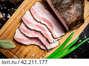 Pieces of pork lard on a cutting board with green onions and bay leaves. Стоковое фото, фотограф Артем Шадрин / Фотобанк Лори