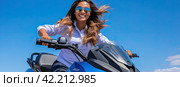 A girl with long wind-tousled hair on a blue motorcycle rides against a background of blue sky. Close-up shooting. Стоковое AI-изображение, AI-художник Ярославский Максим / Фотобанк Лори