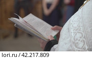 A priest holds a Bible in his hands. Стоковое видео, видеограф Потийко Сергей / Фотобанк Лори