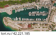 Boats and yachts moored on piers sit peacefully on water. Aerial view of structured nautical vessels in dock. Стоковое видео, видеограф Igor Tichonow / Фотобанк Лори
