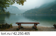 An unadorned wooden lectern, perfectly aligned with a serene lakeside landscape. Стоковое AI-изображение, AI-художник Юлия Гапеенко / Фотобанк Лори